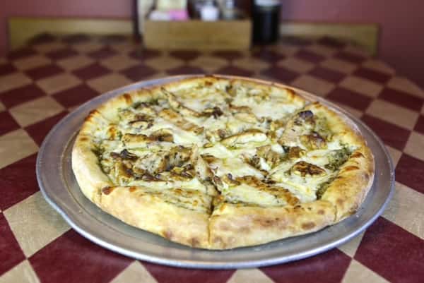 a pizza pie with cheese and chicken