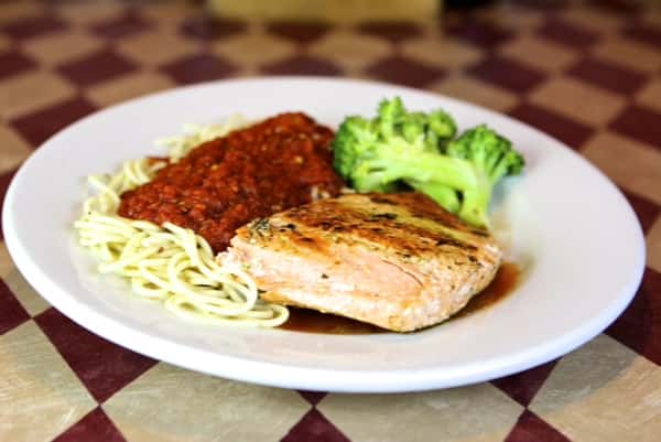 a spaghetti with marinara with salmon and a side of broccoli