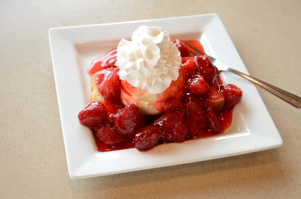 strawberry cheesecake with whipped cream on top