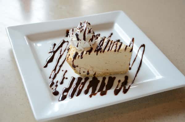 cheesecake with chocolate syrup and whipped cream