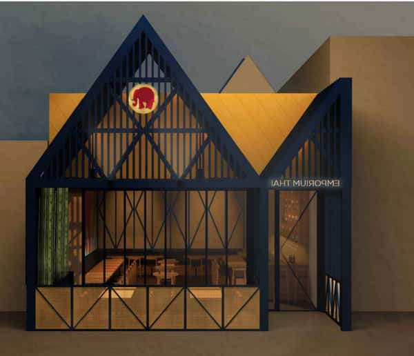 Modern restaurant exterior with angular black lattice facade, warm interior lighting, and a circular red elephant logo above the entrance.