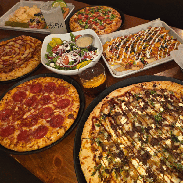 multiple pizzas on table