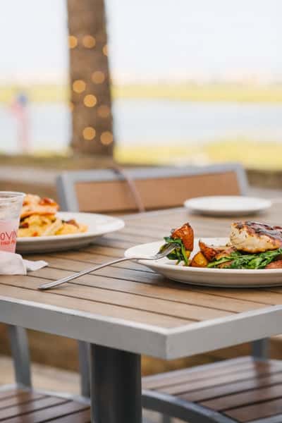 Signature coastal platter at Bovine's in Murrells Inlet, SC, featuring barbecue ribs, buffalo wings, cheesy stuffed mushrooms, meatball sliders, crispy fries, and a cold Blue Moon—served dockside at this beloved waterfront restaurant.