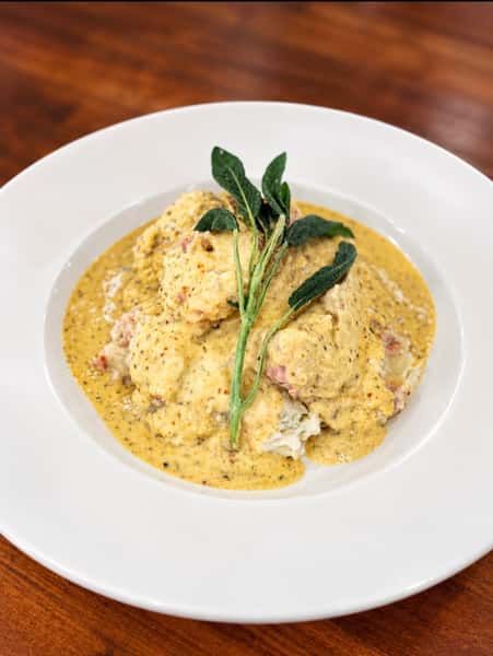 Milk Braised Pork Loin

Served over mashed potatoes loaded w/ smoked sausage & sauerkraut topped w/ whole grain mustard pan gravy