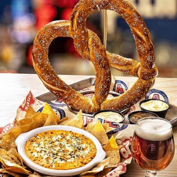 Large pretzel, dips and beer