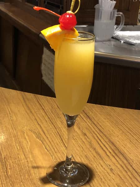 mimosa with orange garnish on bar