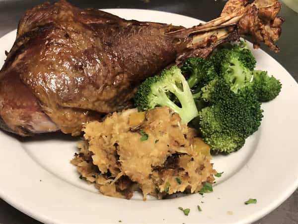 turkey leg with stuffing and broccoli on a plate