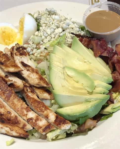 cobb salad: Chopped salad greens, tomato, crispy bacon, grilled chicken breast, hard-boiled egg, avocado, bleu cheese, with vinaigrette dressing.