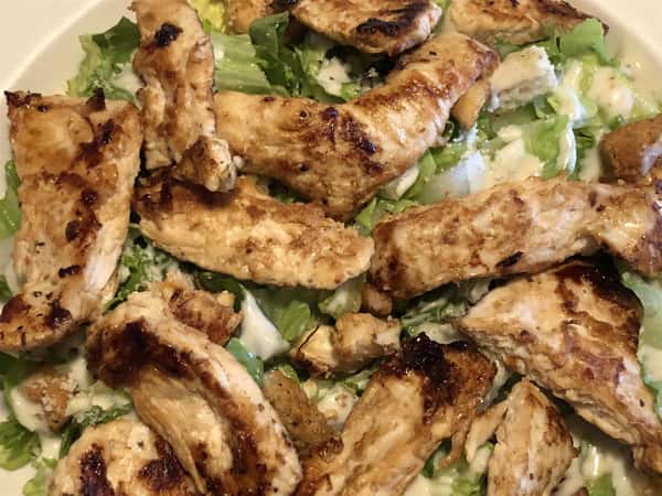 A close up of A grilled chicken cesar salad