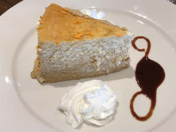 cheesecake with whipped cream and chocolate sauce