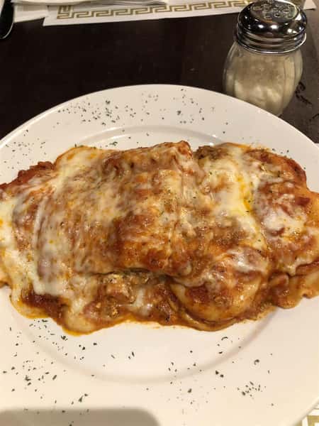 Italian Sampler Trio, Baked Lasagna, stuffed shells and ravioli on a white plate