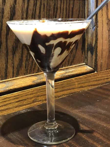 alcoholic beverage in a martini glass with chocolate and cream