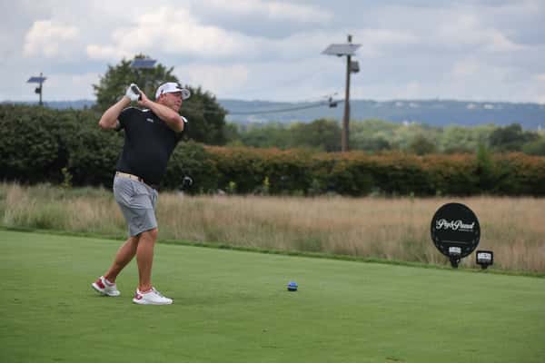 Marty Brouder hitting golf ball fundraiser at Pig hole