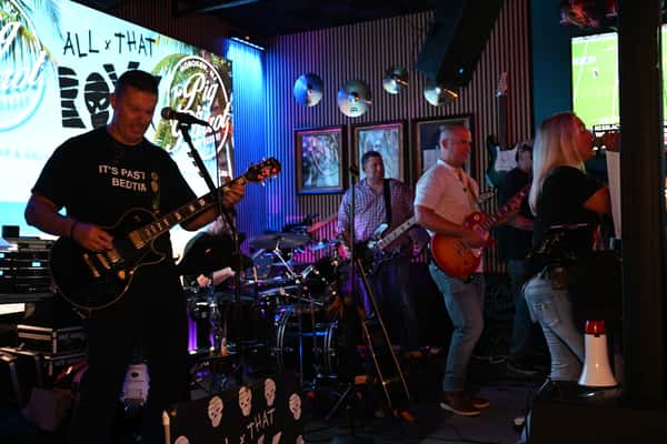 multiple musicians with guitars and microphones