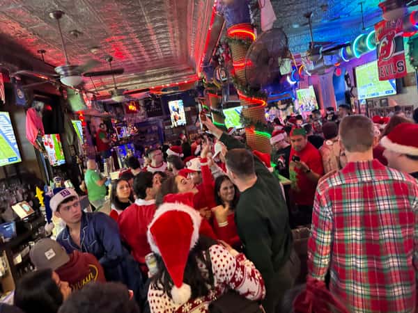inside busy bar santa con customers dressed as santa