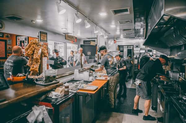 Interior view of staff working behind the counter serving customers in line