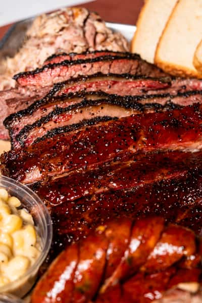 Closeup of bbq platter with brisket, ribs, sausage and macaroni and cheese