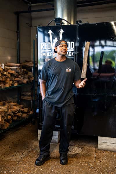 Employee tossing a plank of wood in the smokeroom