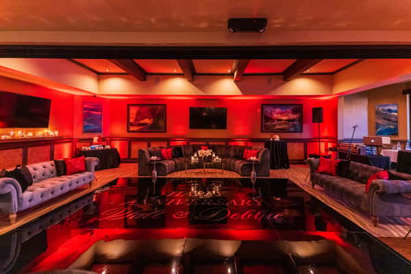 rented lounge furniture and dance floor with parties name on the dance floor with red lighting