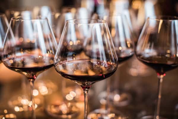 several wine glasses filled with red wine
