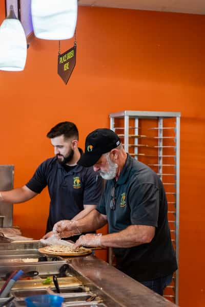 men working and preparing pizza