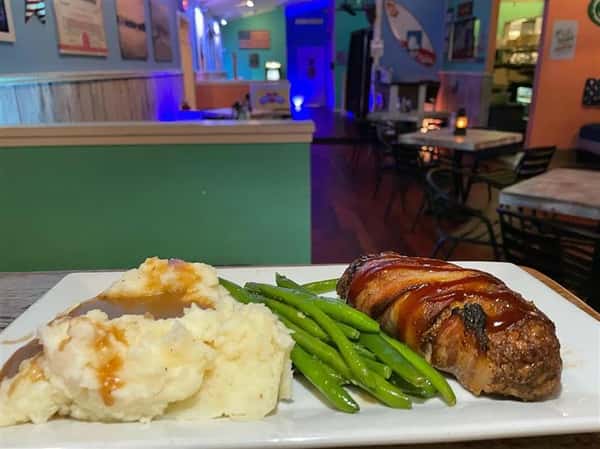 meatloaf wrapped in bacon with green beans and mashed potatoes