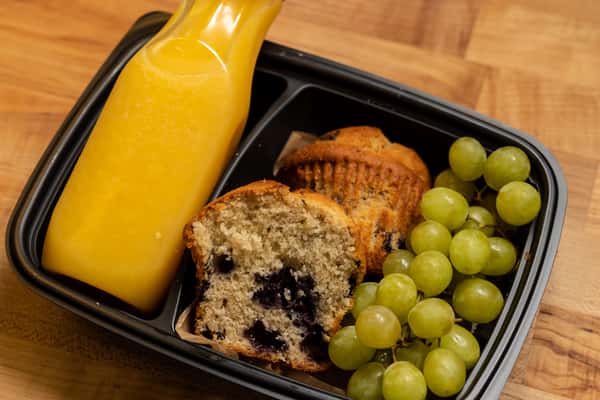 Breakfast box with juice, fruit, and pastries