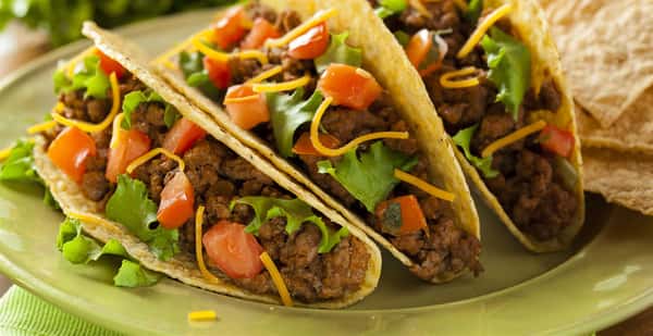 Three beef tacos in hard corn shells with lettuce, tomato and cheese - Copy