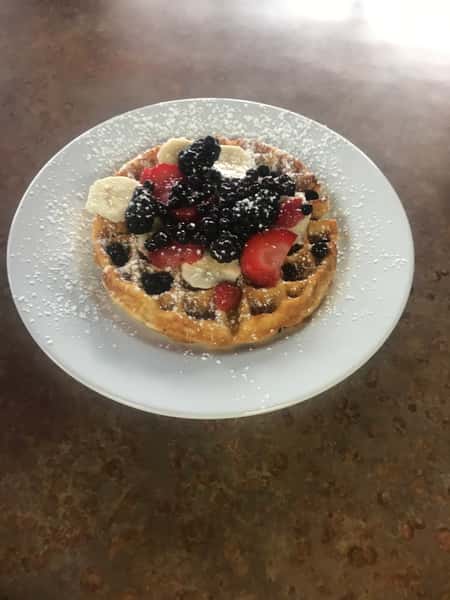 Delicious waffles topped with fresh fruit and powdered sugar