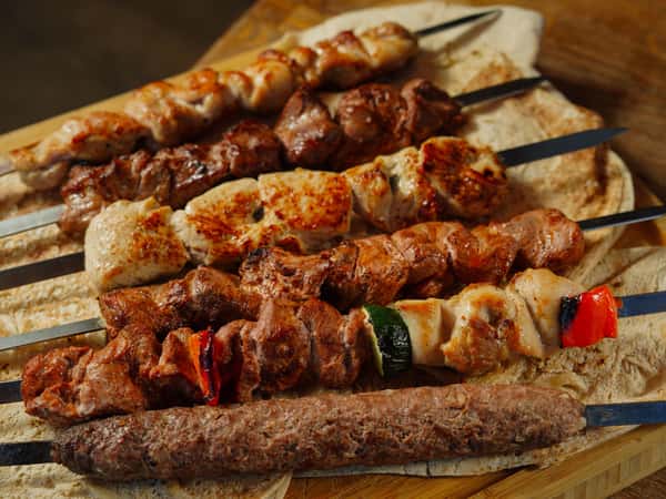 a-variety-of-grilled-meat-skewers-served-on-flatbread