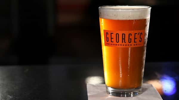 a George's Neighboorhood Grill glass with beer inside