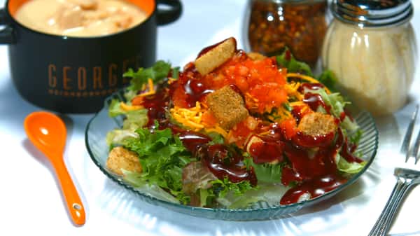 Salad with cheese, croutons and chopped tomato with a dressing on top