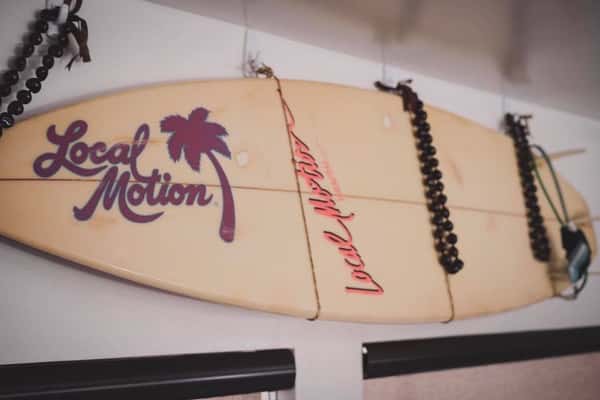 surf baord with "local motion" painted on it