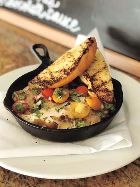 cooked vegetables in a skillet with toast
