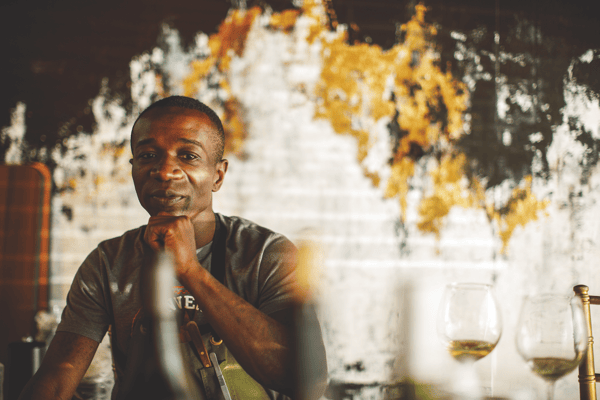 Photo of chef Hyde seated next to glasses of wine