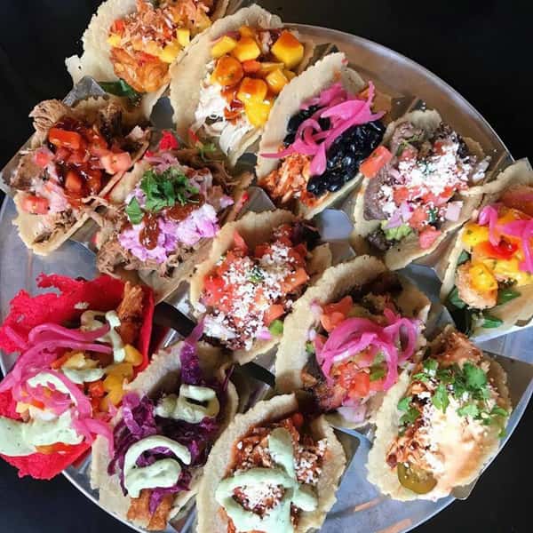 An assortment of tacos with different toppings on a tray
