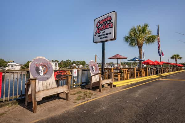 Oversize adirondack wood chairs with Captain Archie's logos printed on the back rest