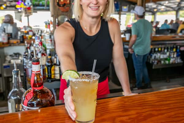 Bartender happily holding out a drink