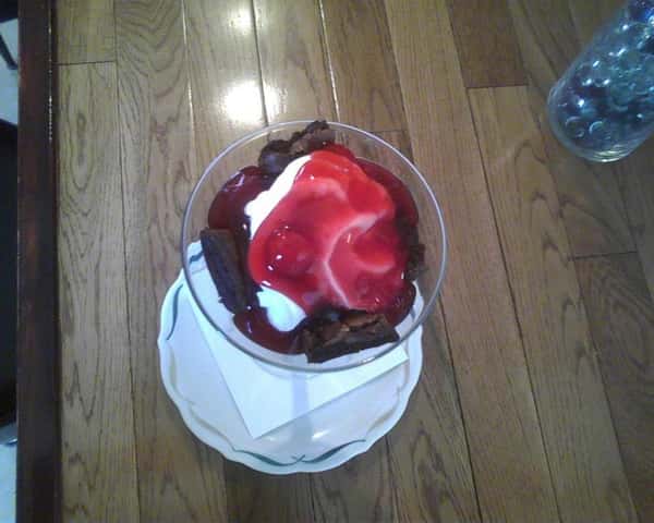 martini glass filled with chocolate dessert with strawberries and whipped cream