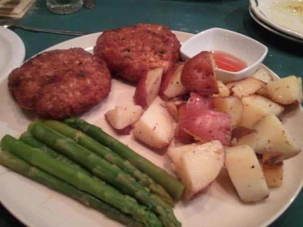 beef patties with a side of cooked potatoes and asparagus