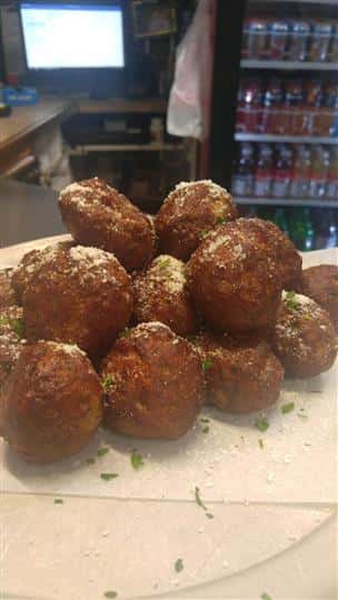 baked italian meatballs stacked up on a table