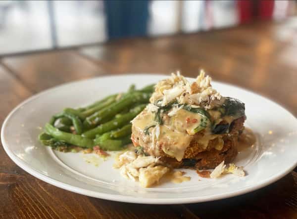 14 oz Hand-Cut Cajun Ribeye: handcut ribeye blackened with creole butter, served with a stuffed potato and green beans