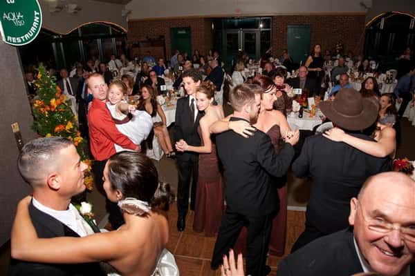 crowded dining area filled with people dancing together dressed up