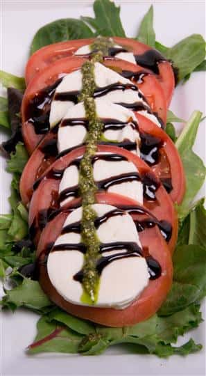 caprese salad over a bed of spinach