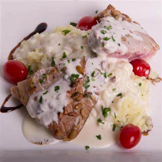 cooked meat over risotto with tomatoes