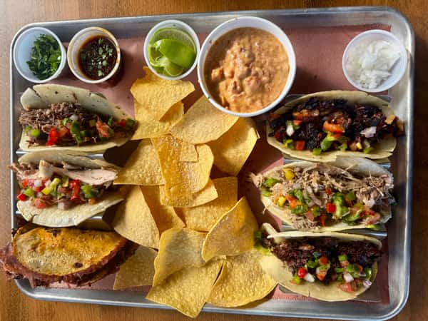 Above view of a platter of tacos, chips, and dips