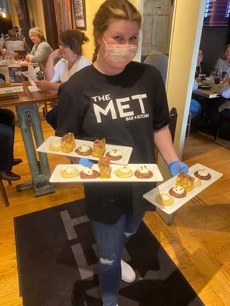 staff member holding three plates of desserts