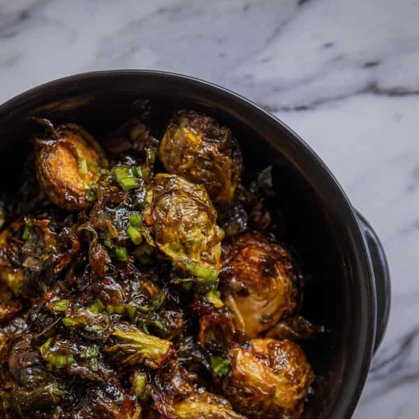 Crispy roasted Brussels sprouts in a black bowl