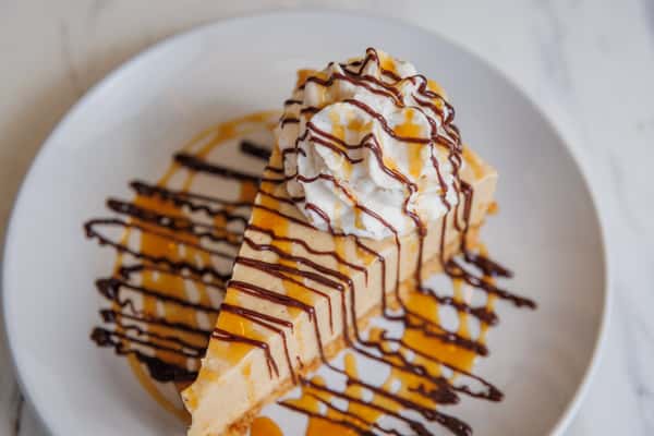 Dessert topped with whipped cream and drizzled with caramel and chocolate sauce