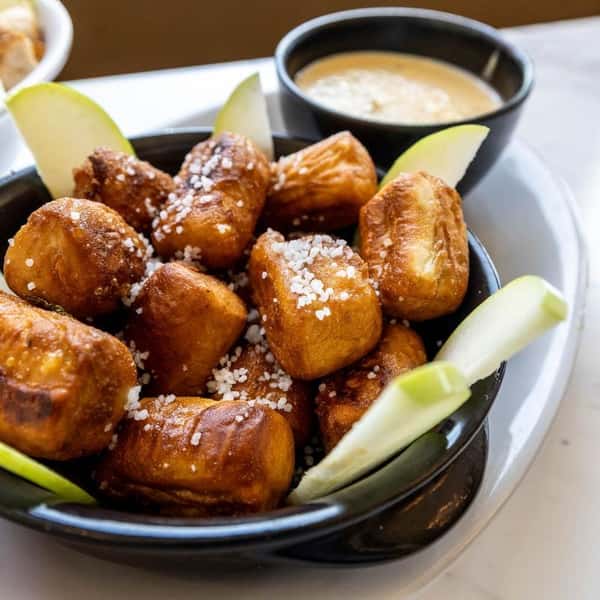 Glazed crispy bites served with green apple slices and a side of dipping sauce